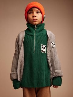Red knitted beanie featuring a Ritzratz patch worn by a model.