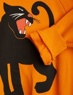 Close-up of the orange sweatshirt showing the black panther print on the front.