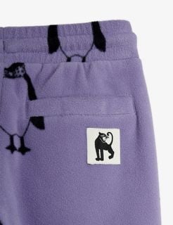Close-up of purple trousers with a Penguin print, a back pocket, and a panther label.