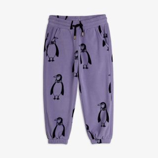 Purple trousers with an all-over penguin print, drawstring waist, side pockets, and elastic cuffs.