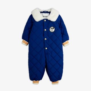 Blue quilted baby overall with a white faux-fur collar, Ritzratz patch, and striped ribbed cuffs.