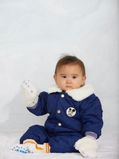 Blue quilted baby overall with a white faux-fur collar, snap buttons, and a Ritzratz chest patch.