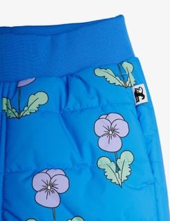 Close-up of blue padded trousers with a Violas print, a ribbed waistband, and a side label.