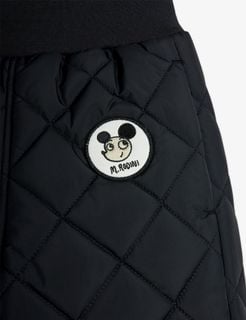 Close-up of a black quilted outerwear trousers featuring a round Ritzratz character patch.
