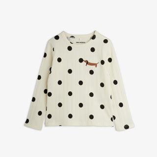 Off-white long-sleeved top featuring a black dot pattern and a dachshund dog motif on the chest.