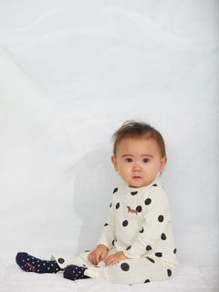 Off-white long-sleeved top with a black dot pattern and a small dog motif.