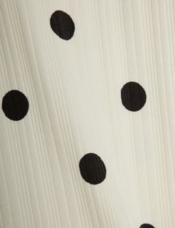 Close-up of off-white ribbed fabric featuring a black Dots print.