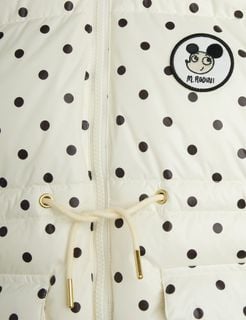 Close-up of an off-white heavy puffer jacket with black polka dots and a Ritzratz patch.