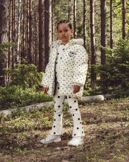 Off-white heavy puffer jacket featuring polka dots and a Ritzratz patch, worn outdoors.