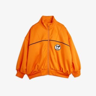 Orange recycled polyester tracksuit jacket featuring a Ritzratz patch, navy piping, and ribbed cuffs.