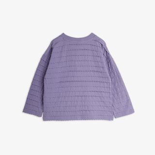 Purple long-sleeved blouse with horizontal textured frill rows and a ribbed rounded neckline, shown from the back.