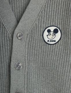 Close-up of a grey knitted cardigan featuring a circular Ritzratz patch and buttons.