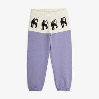 Purple sweatpants featuring an off-white front panel with black Panther prints and ribbed cuffs.