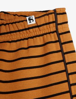 Close-up of brown and black striped sweatpants featuring an elasticated waistband and a small white panther logo tag.