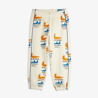 Off-white sweatpants featuring a colorful Velvet worms print, blue side piping, elastic waist, and cuffs.