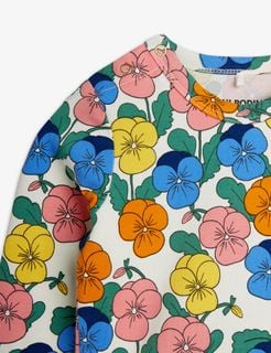 Close-up of a multi-color bodysuit with a vibrant Viola flower print and snap buttons at the shoulder.
