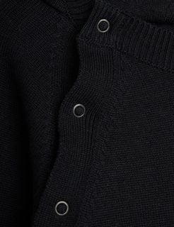 Metal snap button and ribbed neckline detail on a black fine knit baby jumpsuit.