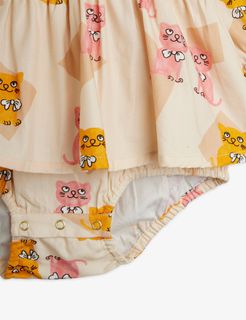 Close-up of a beige bodysuit featuring the Kittens print, a ruffled hem, and snap-button closure.