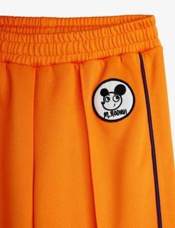 Orange recycled polyester trousers with a Ritzratz patch, featuring an elastic waistband and striped side piping.