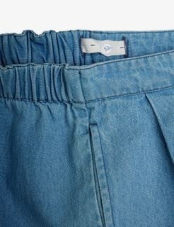 Close-up of the adjustable elastic waistband and front pleats on blue trousers.