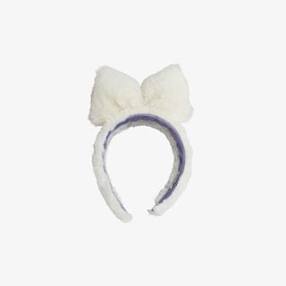 Off-white faux fur headband with a large bow detail and a contrasting purple lining.