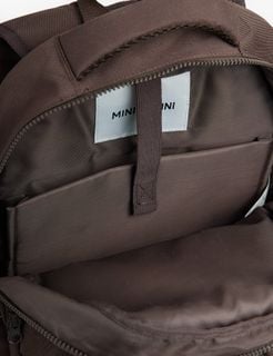 Brown school backpack interior showing lining, inner pocket, zipper, and brand label.