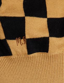 Close-up of brown and black chess check knitted fabric featuring small M.R embroidery and a ribbed texture.