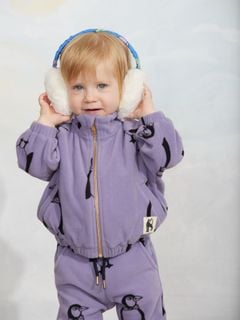 Off-white faux fur ear muffs with a blue patterned headband.