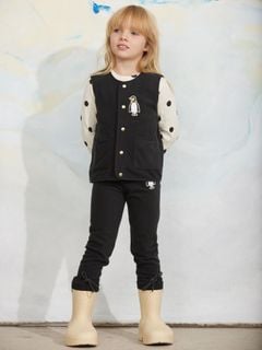 Black microfleece vest featuring a penguin patch and front pockets, worn by a child.