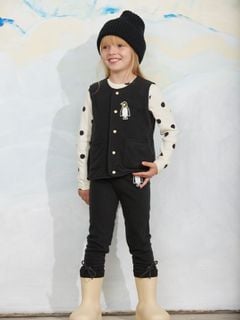 Black microfleece vest featuring a penguin patch, snap-button closure, and front pockets, worn by a child.