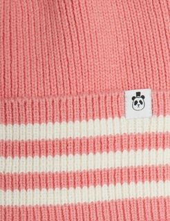 Close-up of a pink knitted beanie featuring a striped folded brim and a panda label.
