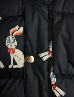 Close-up of a black puffer jacket featuring a Rabbits print and a gold snap button.