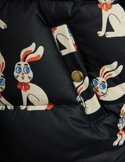 Black puffer jacket close-up featuring a white Rabbit print and gold snap button.