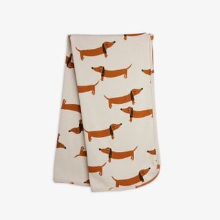 Grey swaddle blanket featuring a repeated brown dachshund dog print.