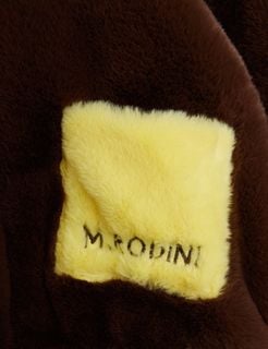 Yellow faux fur pocket with M. Rodini embroidery on a brown faux fur jacket.