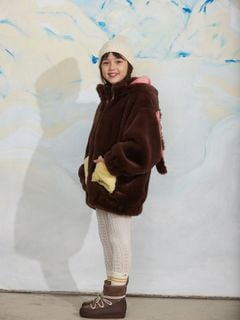 Brown faux fur jacket with a rabbit-ear hood and yellow front pockets, worn by a child.