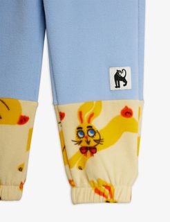 Blue fleece trousers featuring contrast yellow Rabbits print panels and a small black panther label.