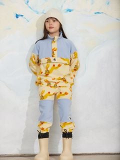 Yellow fleece trousers with a rabbit print and blue contrast knee panels, worn by a child.
