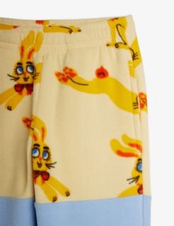 Yellow fleece trousers with a Rabbits print, showing a close-up of the elastic waistband and side pocket.
