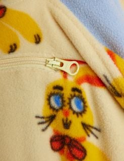 Close-up of the yellow half-zip and Rabbits print on a yellow fleece sweater.