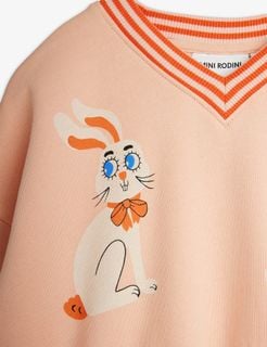 Striped V-neck and white Rabbits print with blue eyes and orange bow on pink sweatshirt.