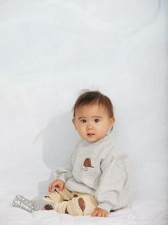 Grey melange sweatshirt with an embroidered elephant shrew motif, worn by a child.