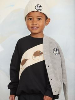 Black sweatshirt with Elephant shrew panel print, worn by a child wearing a beanie and grey cardigan.