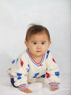 Off-white sweatshirt with Kittens print, worn by a baby.