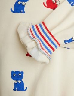 Ribbed striped cuff in red and blue on an off-white sweatshirt featuring a blue Kittens print.