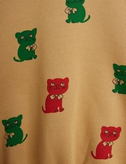 Close-up of beige sweatshirt featuring a Kittens print with red and green cats.