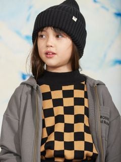 Grey zip-up hoodie worn by a child wearing a black beanie and a black and yellow checkered sweater.