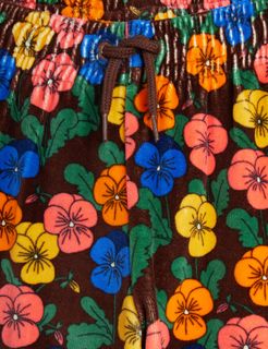 Brown velour trousers featuring colorful Violas print, an elasticated waistband, and brown drawstring detail.