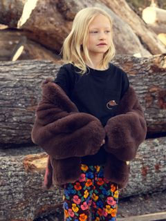 Multi-colored Violas print velour trousers worn by a child wearing a dark furry jacket.
