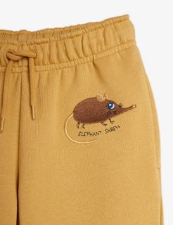 Beige sweatpants featuring an elastic drawstring waistband and brown Elephant Shrew embroidery.